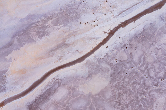 Narrow stream of water running through a dry salt lake