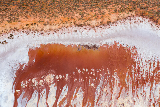 Rusty colored minerals seeping into a dry salt lake bed