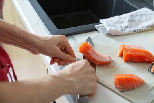 Hands preparing fresh salmon fillet for cooking