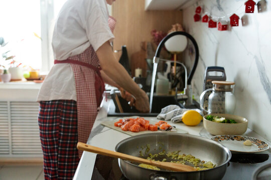 Person cooking salmon and vegetables for healthy meal