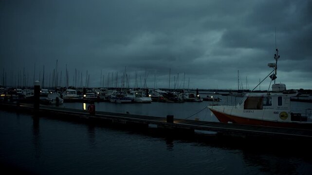 A night time shot of a pier with dark grey clouds rolling in. Ireland.