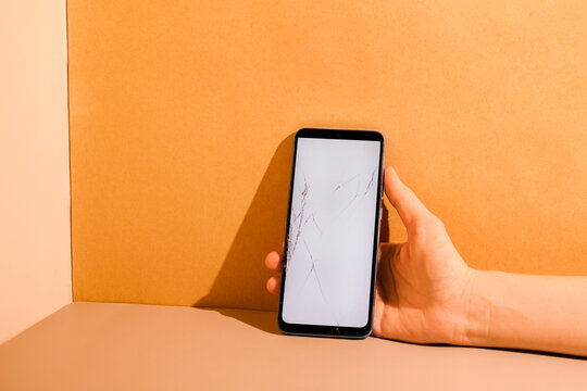 Smartphone with cracked screen at the table.