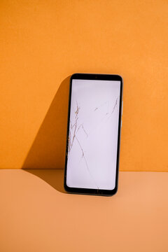 Smartphone with cracked screen at the table.