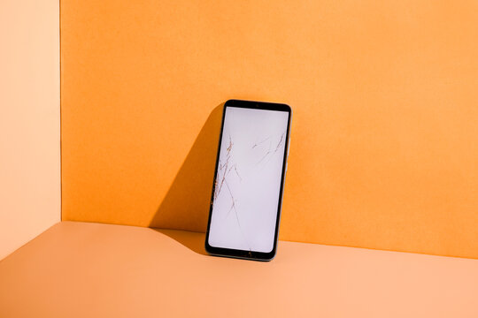 Smartphone with cracked screen at the table.