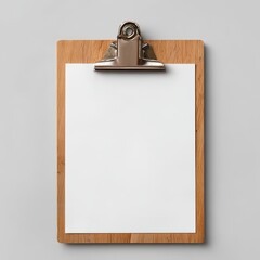 A wooden clipboard holds a blank white sheet of paper on a gray surface