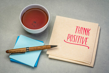 Think positive - deliberate mental practice of choosing interpretations that support action, resilience, and growth. Inspirational reminder note on a napkin.