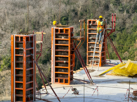 Workers Installing Concrete Column Forms at Construction Site