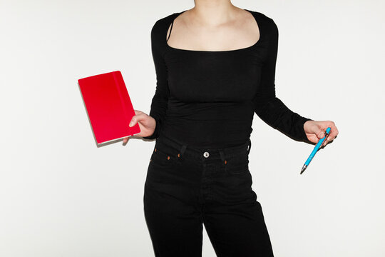 Person holding colourful  book and pen in office and studying/learning