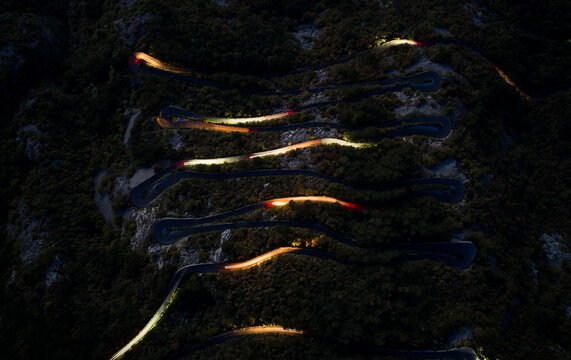 Night Traffic on winding Mountain Road with Light Trails, top down