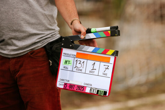 Film director holding a colorful movie clapperboard