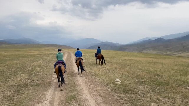 Horse riding in the breathtaking landscape of Song Kul Lake, Kyrgyzstan. 