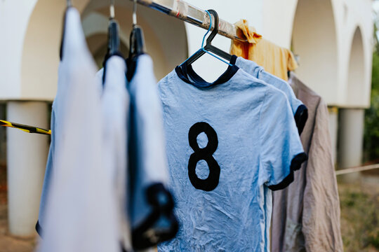 Clothes drying on a rack featuring a blue shirt with a number