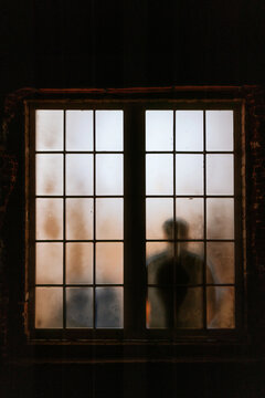 Silhouette of person behind a frosted window at night