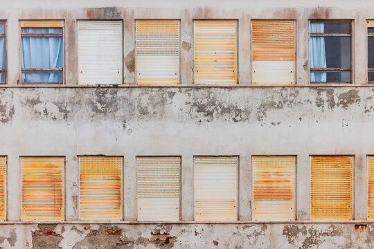 Weathered building facade with closed shutters