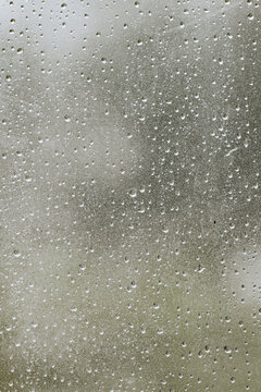 Raindrops on glass creating a natural abstract pattern