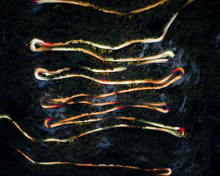 Winding Road With Vehicle Lights at Night in Mountain Area