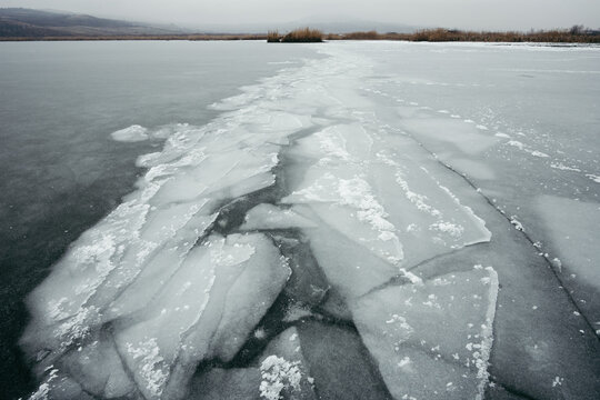 Frozen lake with ice shapes on shore