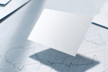 A blank white card mockup floating above stock market graph paper