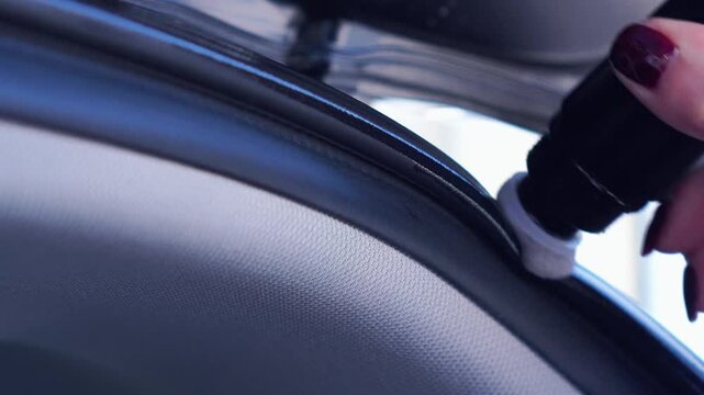 woman lubricates the rubber of the car trunk with silicone in winter. car protection from winter frosts. car care