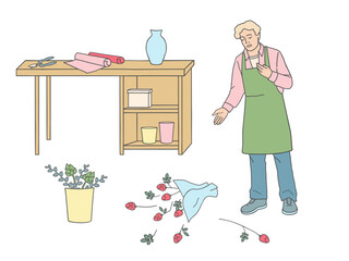 Vector illustration of a male florist in apron near a workbench with scissors and wrapping paper. Fallen bouquet on the floor, flower arrangement process and working moment on white background.