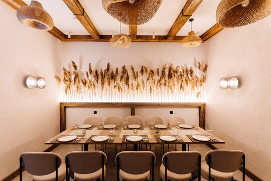 Cozy private dining room with rattan pendants and pampas decor, set table