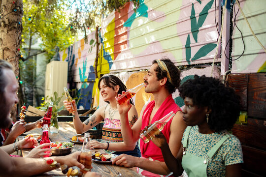 Friends toasting drinks at a colorful backyard patio party