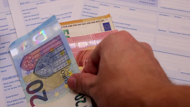 Le formulaire 2042 de d&eacute;claration des imp&ocirc;ts sur le revenu 2026 avec des billets d'euros.