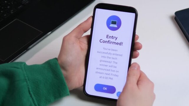 Person participating in an online prize draw. Smartphone confirms giveaway entry in a modern office setting. Great for tech brands, internet marketing ads, and mobile app walk-throughs. Versatile