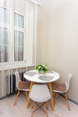 Bright minimalist dining corner with round white table