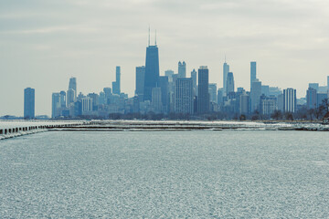Winter scene in Chicago with ice on the lake and skyline in the background during a cloudy day