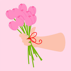 A woman's hand holds a bouquet of pink tulips for Mother's Day
