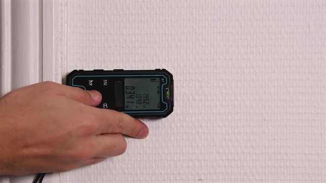 Gros plan sur un t&eacute;l&eacute;m&egrave;tre laser pour mesurer la surface d'un bien immobilier.