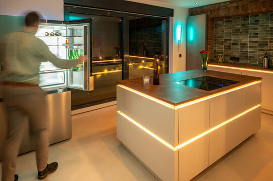 Luxury Kitchen Interior Design: Side-by-Side Refrigerator and Seamless Flooring with modern LED Ambient Lighting and Corten Steel Countertop