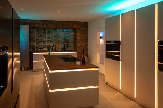Luxury Kitchen Interior Design: Side-by-Side Refrigerator and Seamless Flooring with modern LED Ambient Lighting and Corten Steel Countertop