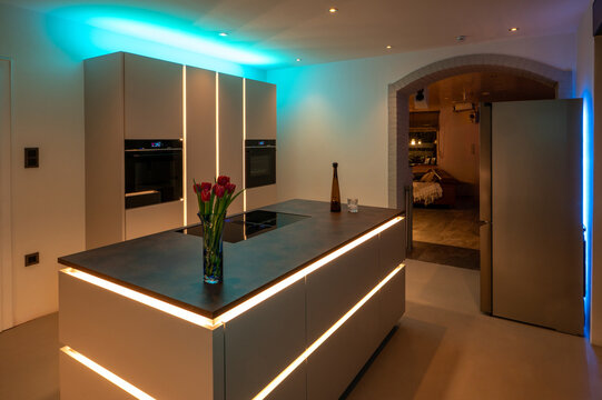 Luxury Kitchen Interior Design: Side-by-Side Refrigerator and Seamless Flooring with modern LED Ambient Lighting and Corten Steel Countertop