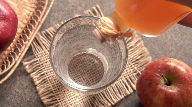 Pouring apple cider vinegar into a glass of water, slow motion