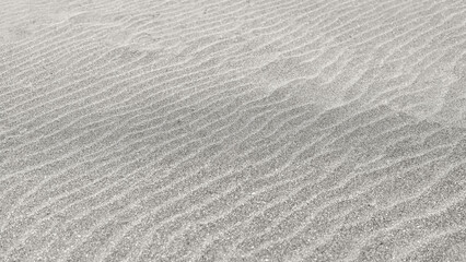 Obraz premium Fine sand surface with natural wind wave pattern forming minimal texture in cloud dancer color used as background, mockup for design. Natural sand texture, neutral surface, copy space, background