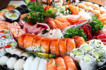 Party tray with sashimi, sushi and maki rolls, shallow focus