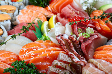 Party tray with sashimi, sushi and maki rolls, shallow focus
