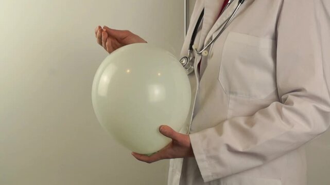 A professional doctor in a white lab coat uses a medical needle to pop a white balloon, symbolizing sudden health crisis, fragility, or the bursting of medical myths.