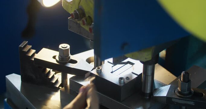 Factory metalworking process with stamping press, industrial mold and machinery creating metal components for production.