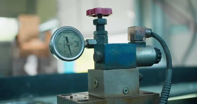 Pressure gauge showing hydraulic fluid pressure on industrial machine. Process control and operational safety in manufacturing equipment