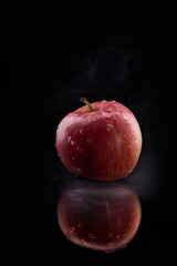 Red apple with water droplets reflected on black © Juanma