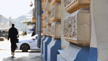 Urban scene with blurred pedestrian walking past building facade detail © Довидович Михаил
