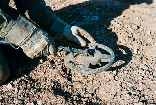 Deminer using metal detector for landmine clearance