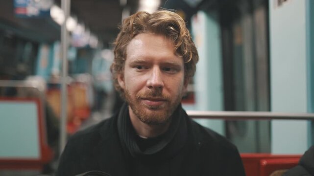 Young man smiling while riding subway train