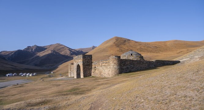 Historic caravanserai Tash Rabat from the 15th century, with yellow hills, Atbashy district in the Naryn region, Kyrgyzstan