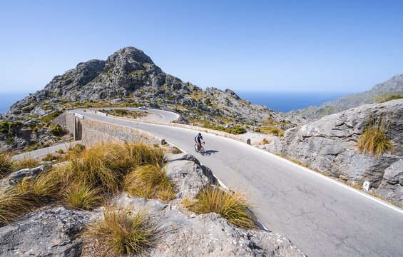 Road cyclists at the mountain pass with serpentines to Sa Colobra, Nus de Sa Corbata road loop, Serra de Tramuntana, Majorca, Balearic Islands, Spain