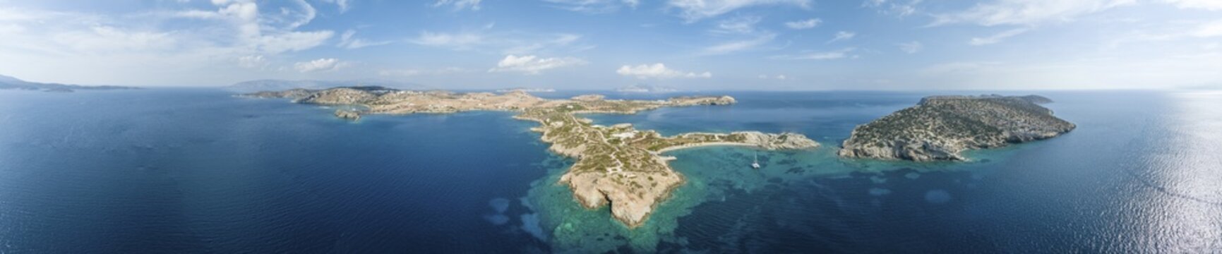 Aerial view, sailing catamaran in a bay on the Turquoise Sea, panorama of the island of Schinoussa, Small Cyclades, Greece