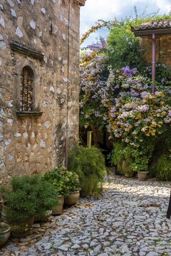 Inner courtyard with flowers, stone building, Moni Agnountos Monastery, Peloponnese, Greece